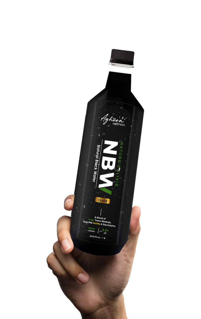 A hand holding a bottle of Aghora Wellness Natural Black Water GOLD
